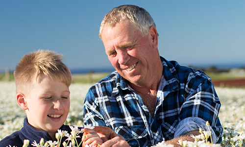 Farmer Peter Langmaid looking at flowers with a child